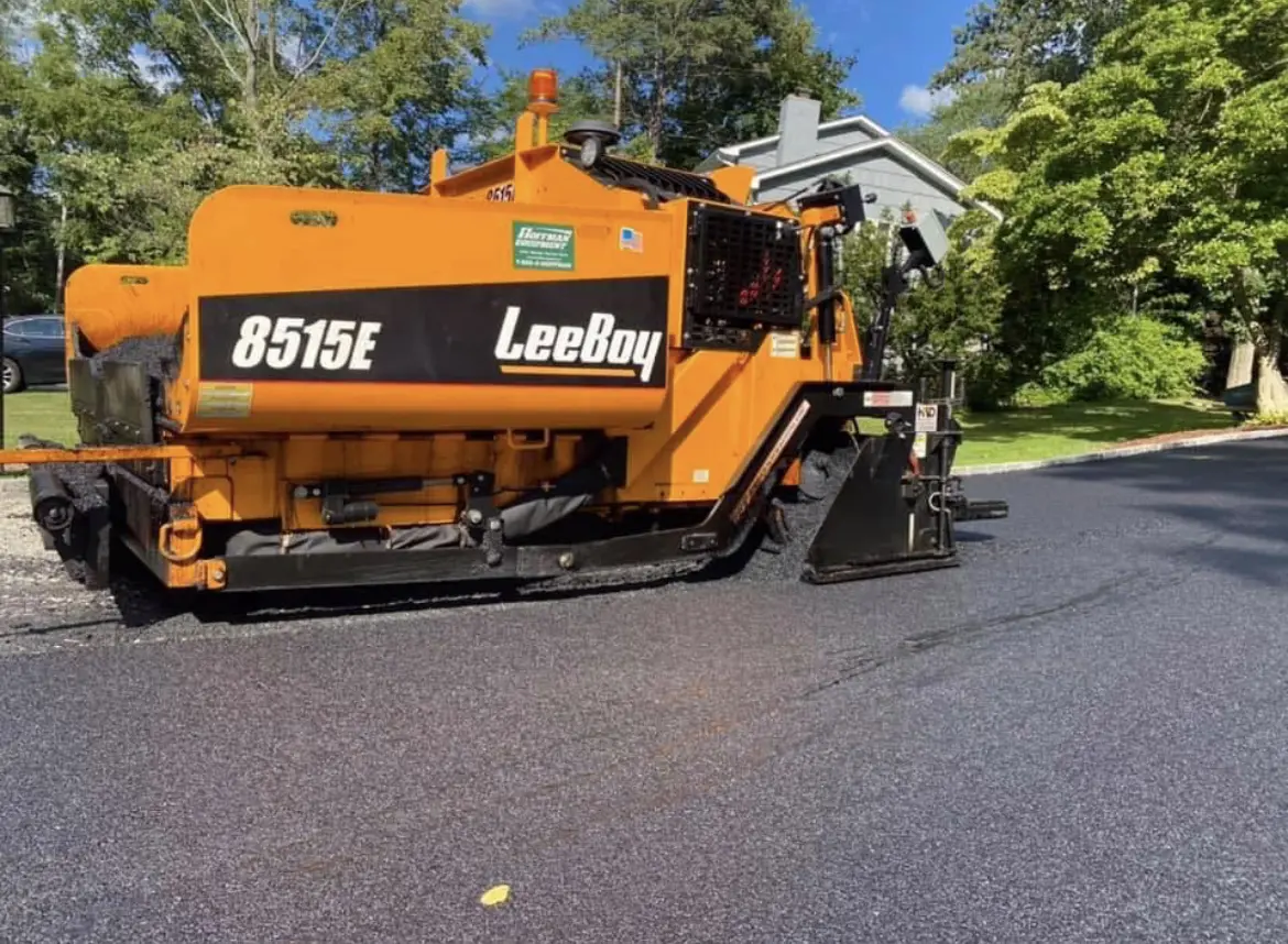 A street sweeper is parked on the side of the road.