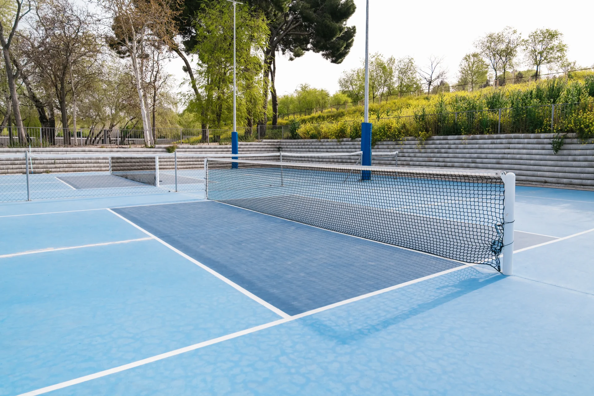 empty-pickleball-court-with-blue-surface-and-net-2025-03-08-16-43-58-utc_compressed