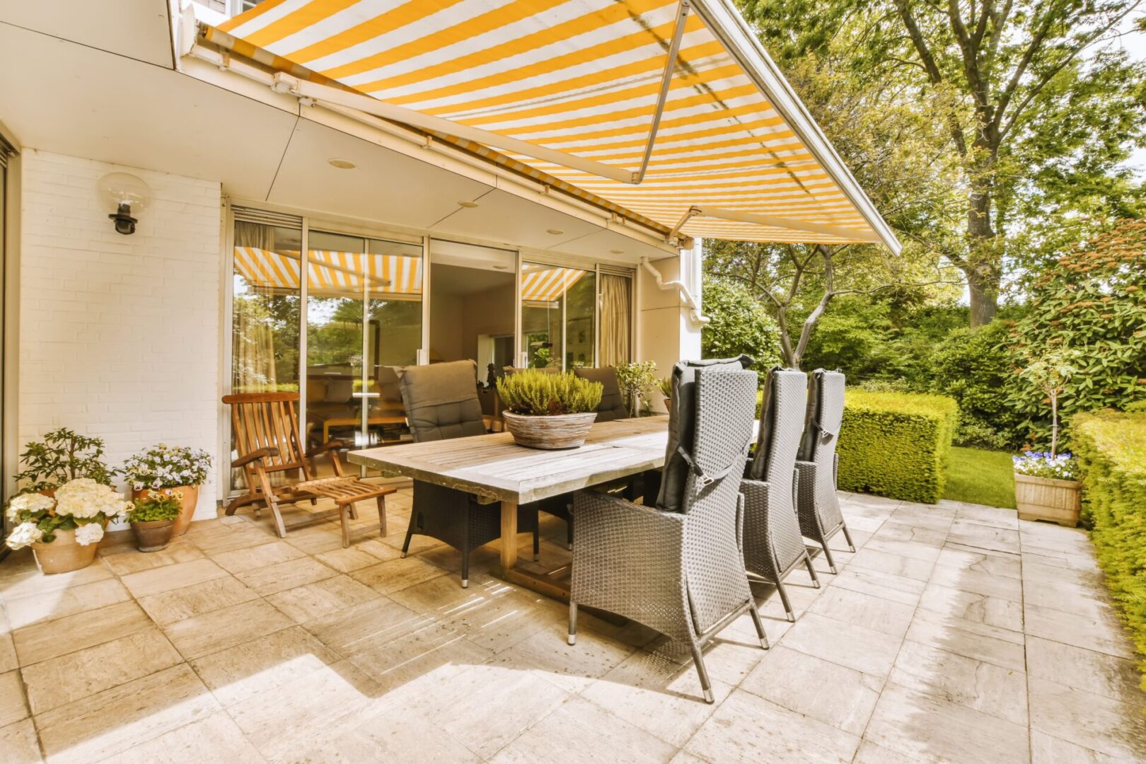 Wooden table and wicker chairs on tiled patio