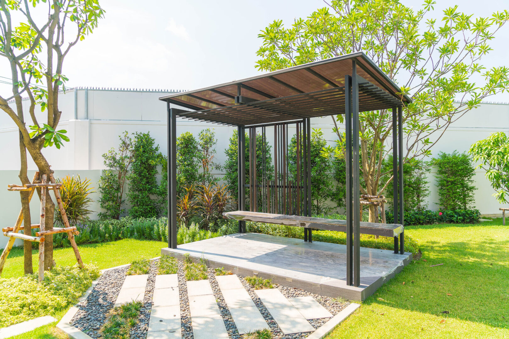 Modern pergola with bench in sunny garden