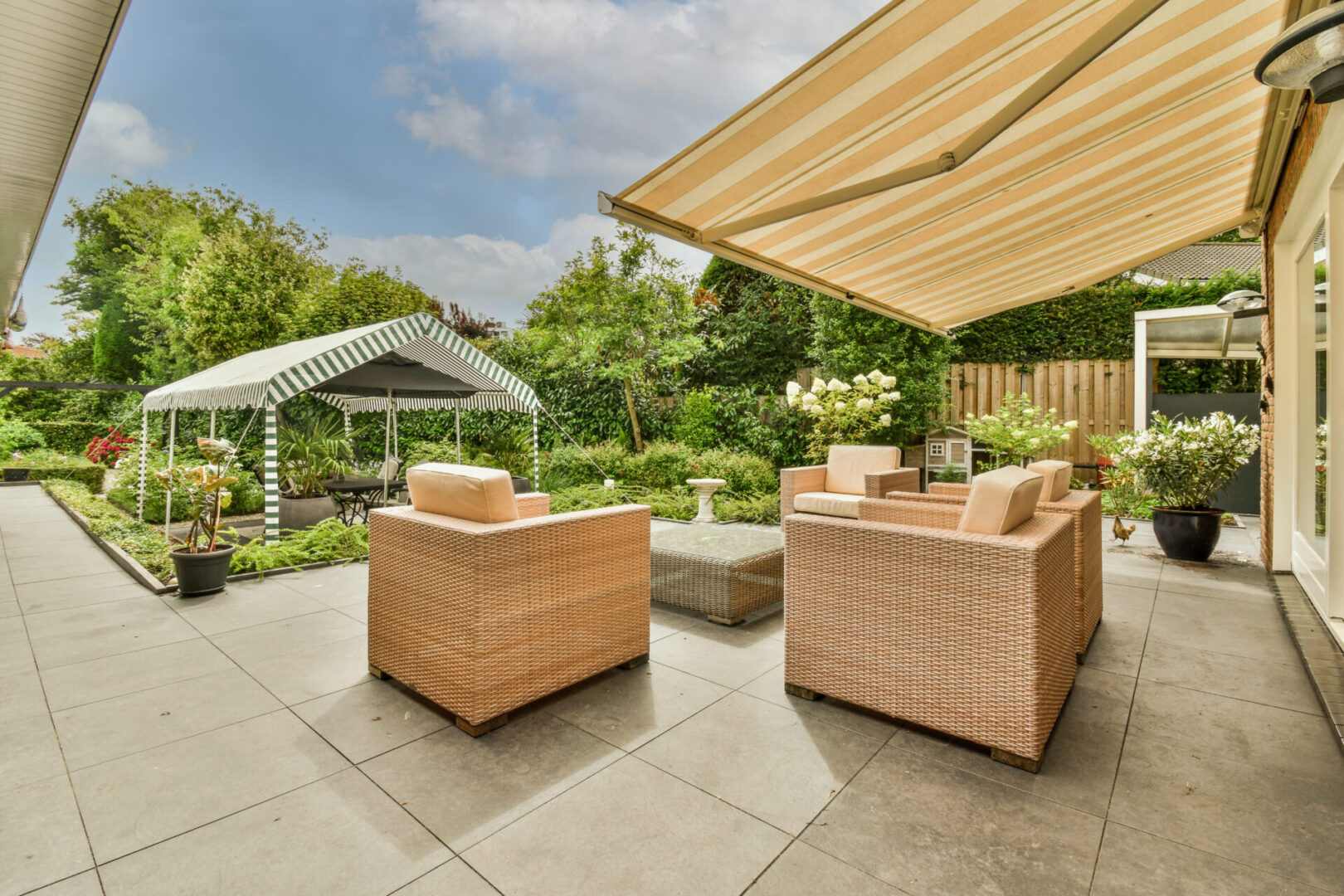 Outdoor patio with wicker chairs and awning
