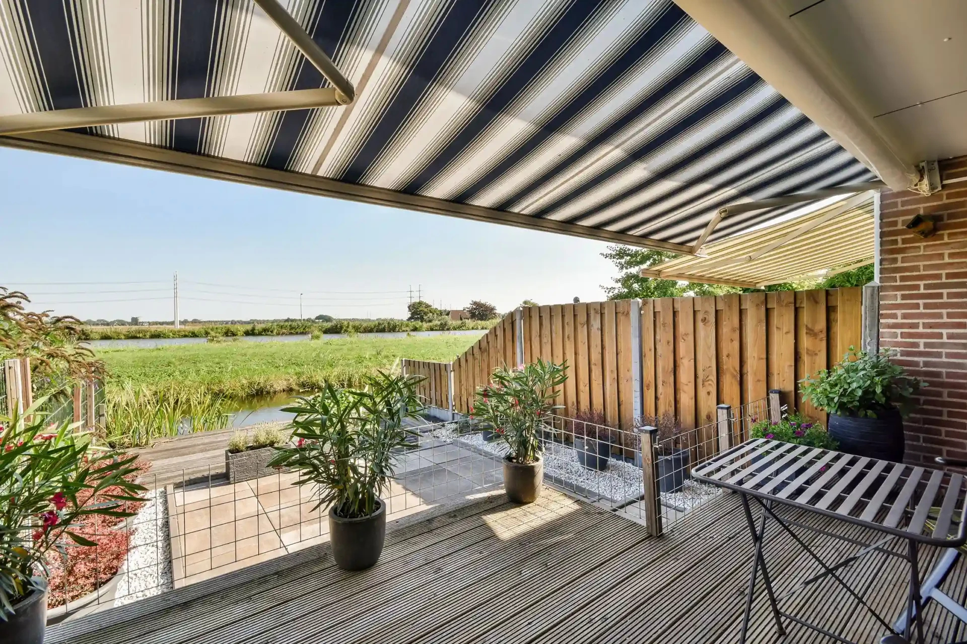 Striped awning over patio overlooking river view