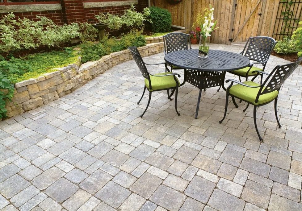 Stone patio with round table and green chairs